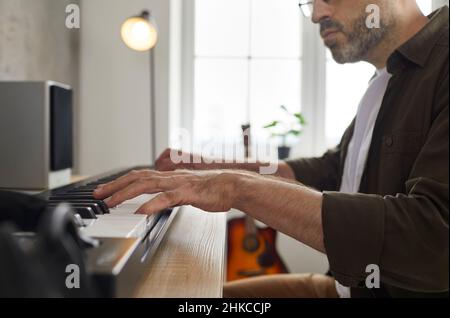Nahaufnahme der Hände eines professionellen Musikers, der im Musikstudio auf Synthesizer spielt. Stockfoto
