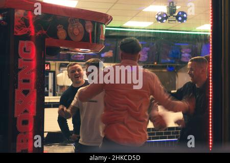 Männer feiern im Rahmen eines Abends in Newcastle upon Tyne, Großbritannien, Erfolge beim Boxspiel zum Mitnehmen. Stockfoto