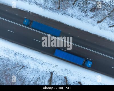 Zwei LKWs im Winter unterwegs, Draufsicht Stockfoto