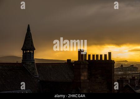 Blick über die Dächer von Edinburgh, wenn die Sonne an einem bewölkten Tag in Schottland untergeht Stockfoto