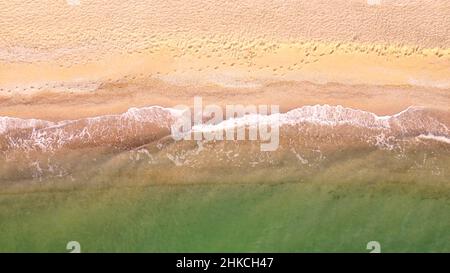 Luftaufnahme des Sandstrandes. Blick auf die Meereswellen von oben. Drohnenaufnahmen. Stockfoto