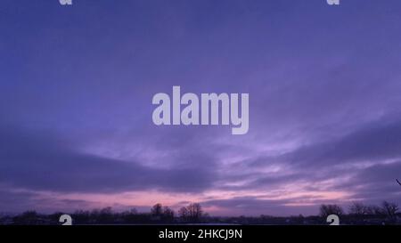 Zeitraffer Sonnenaufgang und Wolken. Lila schöner Himmel im Winter Stockfoto