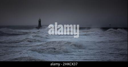 Die Sturmwinde des Sturms Arwen verursachen riesige Wellen, die den Leuchtturm und den Nordpier, die die Mündung des Tyne in Tynemouth, England, bewachen, schlagen Stockfoto