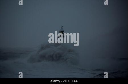 Die Sturmwinde des Sturms Arwen verursachen riesige Wellen, die den Leuchtturm und den Nordpier, die die Mündung des Tyne in Tynemouth, England, bewachen, schlagen Stockfoto