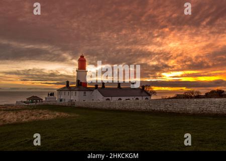 Der rot-weiß gestreifte, 23 Meter hohe Souter Lighthouse und die Leas in Marsden, South Shields, England, wenn die Sonne aufgeht Stockfoto