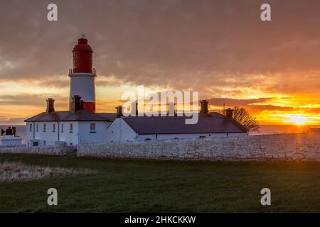 Der rot-weiß gestreifte, 23 Meter hohe Souter Lighthouse und die Leas in Marsden, South Shields, England, wenn die Sonne aufgeht Stockfoto