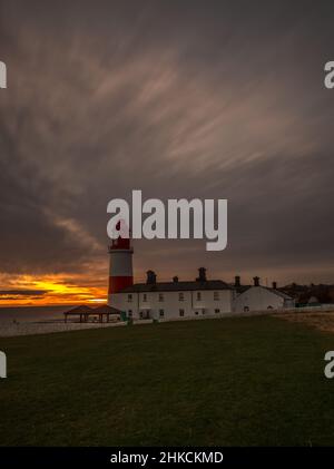 Der rot-weiß gestreifte, 23 Meter hohe Souter Lighthouse und die Leas in Marsden, South Shields, England, wenn die Sonne aufgeht Stockfoto