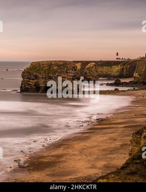 Der Blick entlang der Marshden Bay bei Sunderland, auf die Klippen und das Sandsteinmeer, wenn die Flut eintrifft Stockfoto