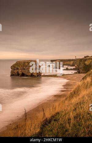 Der Blick entlang der Marshden Bay bei Sunderland, auf die Klippen und das Sandsteinmeer, wenn die Flut eintrifft Stockfoto