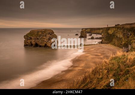 Der Blick entlang der Marshden Bay bei Sunderland, auf die Klippen und das Sandsteinmeer, wenn die Flut eintrifft Stockfoto