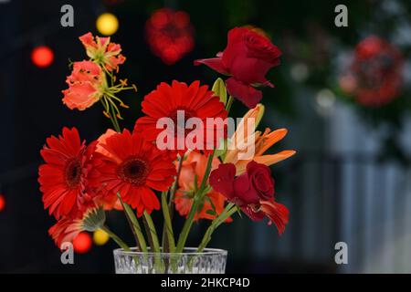 Bunte Blume in Kristallvasen auf einem weißen Tisch. Im Freien Stockfoto