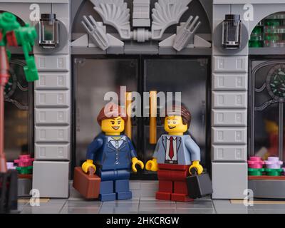 Tambow, Russische Föderation - 01. Februar 2022 Ein Lego-Geschäftsmann und eine Lego-Geschäftsfrau minifiguren das Treffen auf der Straße vor einer Bank. Stockfoto