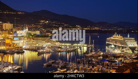 Luftaufnahme des Hafens Hercules in Monaco - Monte-Carlo in der Abenddämmerung liegen viele Yachten und Boote in der Marina, Stadtbild mit Nachtbeleuchtung, Magie Stockfoto