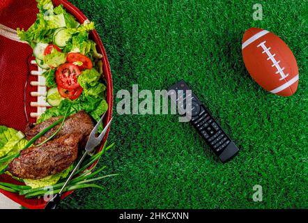 Vorspeisen auf dem Teller mit tv-Fernbedienung für die Fußballparty. Draufsicht. Stockfoto