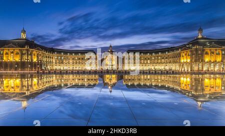 FRANKREICH, BORDEAUX. SONNENUNTERGANG ÜBER DER BOURSE VON BORDEAUX WÄHREND DER BLAUEN STUNDEN. Stockfoto