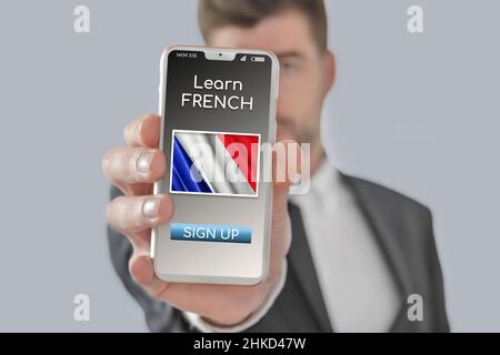 Online-Konzept Französisch lernen Sprache mit einer Person zeigen E-Learning-App auf dem Handy mit der Flagge von Frankreich isoliert Stockfoto
