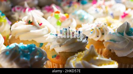 Eine Auswahl an Mini-Cupcakes für den Frühling und Ostern mit dramatischer Beleuchtung. Stockfoto