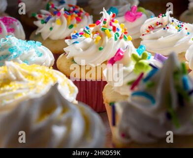 Eine Auswahl an Mini-Cupcakes für den Frühling und Ostern mit dramatischer Beleuchtung. Stockfoto
