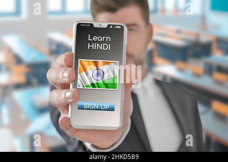 Online-Konzept Lernen Sie die Sprache Hindi mit einer Person, die die E-Learning-App auf dem Mobiltelefon mit der Flagge Indiens zeigt Stockfoto
