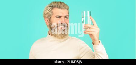 Glücklicher Bartmann, der Wasser trinkt. Männer trinken aus einem Glas Wasser. Gesundheitskonzept, Lebensstil, Nahaufnahme. Lächelnder Mann mit transparentem Glas Stockfoto