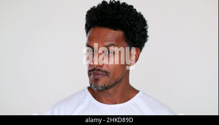 Verdächtiger schwarzer afrikanischer Mann reagiert auf die Kamera. Portrait Kerl reagiert mit Überraschung Stockfoto