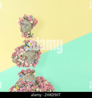 Antike Skulptur des weiblichen Gesichts in einem natürlichen Stil. Creative 3D Illustration Konzept Bunte Körperstatue aus frischen Blumen. Poster auf pastellfarbenem Bac Stockfoto