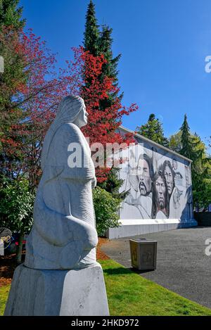 Die Steinskulptur Spirit of the Earth von Daniel Cline und das Wandgemälde von Native Heritage von Paul Ygartua, Chemainus, British Columbia, Kanada Stockfoto