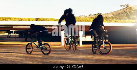 Der perfekte Trick. Ganzkörperaufnahme eines jungen BMX-Reiters, der Tricks in der Stadt macht. Stockfoto