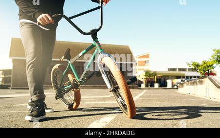 Auf die Straße. Ausgeschnittene Aufnahme eines nicht erkennbaren männlichen BMX-Bikers draußen. Stockfoto