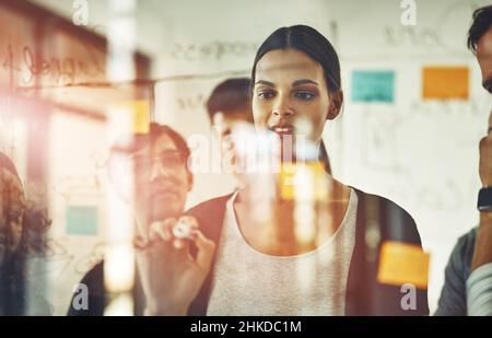 Ich habe große Köpfe hinter mir. Ausgeschnittene Aufnahme einer Gruppe junger Designer mit Haftnotizen während einer Brainstorming-Sitzung. Stockfoto