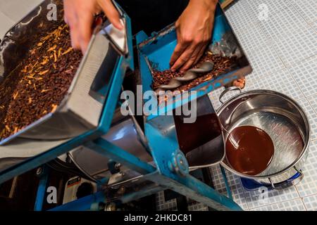 Aus einer Schleifmaschine in der handwerklichen Schokoladenmanufaktur in Xochistlahuaca, Guerrero, Mexiko, fließt ein frischer Kakao. Stockfoto