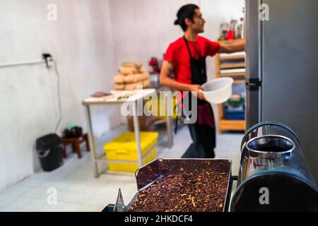 Eine Mahlmaschine, beladen mit zerkleinerten Kakaobohnen gemischt mit Zimt, wird in der handwerklichen Schokoladenherstellung in Xochistlahuaca, Mexiko, gesehen. Stockfoto