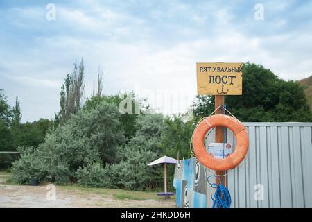 Rettungsstation am Strand an sonnigen Tagen. schild am Ufer. Text auf Ukrainisch: Rettungsposten. Roter Lebensretter. Stockfoto