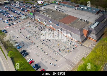 Leeds UK, 10th. April 2020: Menschen in Großbritannien, die nach sozialen Distanzierungsregeln Schlange stehen, um in den Asda-Supermarkt im Dorf Killingbeck zu gehen, Stockfoto