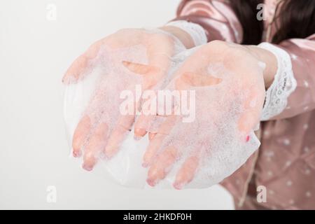 Gesichtspflege und Schönheitsbehandlungen. Sheet feuchtigkeitsspendende Maske auf weißem Hintergrund isoliert. Stockfoto