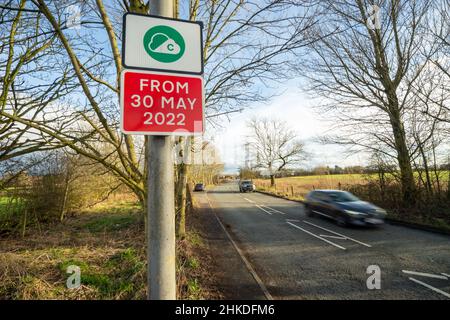 Greater Manchester Clean Air Zone Schild neben einer Straße, wenn der Verkehr vorbeifährt, England, Großbritannien Stockfoto