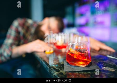 Betrunkener bärtiger Mann schlief an der Bar ein Stockfoto