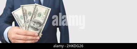 Mann im Anzug hält hundert Dollar Banknoten. Geschäfts-, Finanz- und Gehalt Konzept Stockfoto
