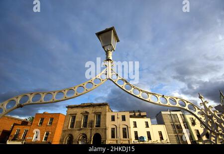 Nahaufnahme der Ha'Penny Bridge (halbe Penny Bridge) von unten mit Temple Bar im Hintergrund, Dublin, Irland Stockfoto