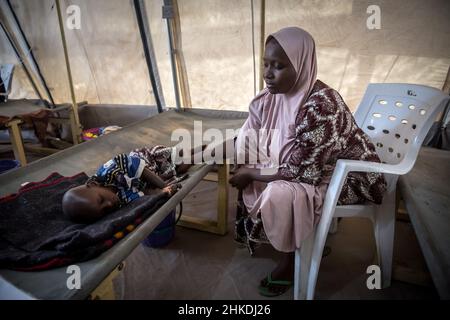 Maiduguri, Nigeria. 25th. November 2021. Aisha Mohammed und ihr zweijähriger Sohn Umar, der wegen Cholera behandelt wird, werden in Maiduguri, der Hauptstadt des Staates Borno, gesehen.die militante islamische Gruppe Boko Haram und kürzlich eine Fraktion namens ISWAP führen seit mehr als einem Jahrzehnt einen Aufstand im Nordosten von Nigeria. Kredit: SOPA Images Limited/Alamy Live Nachrichten Stockfoto