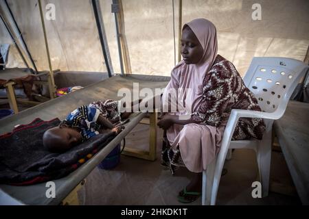 Maiduguri, Nigeria. 25th. November 2021. Aisha Mohammed und ihr zweijähriger Sohn Umar, der wegen Cholera behandelt wird, werden in Maiduguri, der Hauptstadt des Staates Borno, gesehen.die militante islamische Gruppe Boko Haram und kürzlich eine Fraktion namens ISWAP führen seit mehr als einem Jahrzehnt einen Aufstand im Nordosten von Nigeria. (Foto: Sally Hayden/SOPA Images/Sipa USA) Quelle: SIPA USA/Alamy Live News Stockfoto