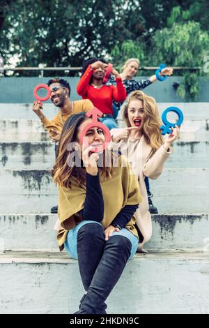 Eine Latina-Frau verwendet scherzhaft ein weibliches Symbol als Lupe. Stockfoto