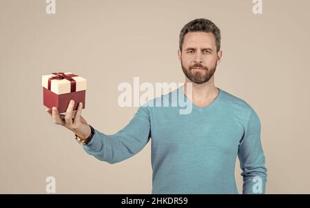 Reifer Mann mit Business-Belohnung. Anlass Gruß. Geschäftsmann zeigt Geschenkbox. Stockfoto