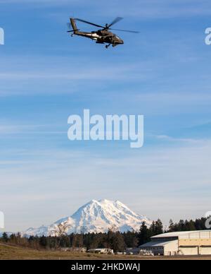 Ein AH-64E Apache-Hubschrauber, der dem 1-229 Attack Bataillon, 16th Combat Aviation Brigade, zugewiesen wurde, hebt am 28. Januar 2022 von der Joint Base Lewis-McChord, Washington, ab. Das Gerät führt regelmäßige Trainingsflüge durch, um die Leistungsfähigkeit zu erhalten und die Bereitschaft zu steigern. (USA Army Photo von Capt. Kyle Abraham, 16th Combat Aviation Brigade) Stockfoto