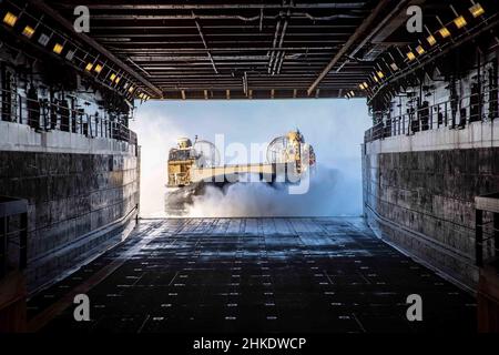 220201-N-PC065-1107 ATLANTISCHER OZEAN – Landungsschiff, Luftkissen 83, angeschlossen an Assault Craft Unit (ACU) 4, tritt in das Brunnendeck des Amphibientransportschiffes USS Arlington (LPD 24) der San Antonio-Klasse ein, 1. Februar 2022. Die Kearsarge Amphibious Ready Group (ARG) und die 22nd Marine Expeditionary Unit (MEU) führen derzeit eine Composit Training Unit Exercise (COMPTUEX) durch. COMPTUEX ist die letzte Übung vor der Bereitstellung, die die Fähigkeit der Kearsarge ARG und 22nd MEU bescheinigt, militärische Operationen durch gemeinsame Planung durchzuführen und anspruchsvolle und realistische Szenarien auszuführen. (USA Navy-Foto Stockfoto