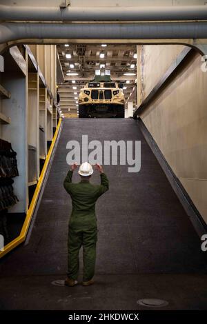 220201-N-PC065-1133 ATLANTIK – Lanze CPL. Jose Liranzo, der an die Marine Expeditionary Unit 22nd angeschlossen ist, steuert ein Joint Light Tactical Vehicle auf einer Rampe an Bord des Amphibientransportschiffes USS Arlington (LPD 24) der San Antonio-Klasse, 1. Februar 2022. Die Kearsarge Amphibious Ready Group (ARG) und die 22nd Marine Expeditionary Unit (MEU) führen derzeit eine Composit Training Unit Exercise (COMPTUEX) durch. COMPTUEX ist die letzte Vorbereitungs-Übung, die die Fähigkeit der Kearsarge ARG und 22nd MEU bescheinigt, militärische Operationen durch gemeinsame Planung durchzuführen und anspruchsvolle und r auszuführen Stockfoto