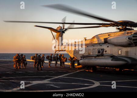 220201-N-PC065-1052 ATLANTISCHER OZEAN – an die Marine Expeditionary Unit 22nd angeschlossene Marineinfanteristen besteigen einen CH-53E Super-Hengst-Hubschrauber, der Marine Medium Tiltrotor Squadron (VMM) 263 (verstärkt) zugewiesen wurde, auf dem Flugdeck des amphibischen Transportschiffes USS Arlington (LPD 24) der San Antonio-Klasse, 1. Februar 2022. Die Kearsarge Amphibious Ready Group (ARG) und die 22nd Marine Expeditionary Unit (MEU) führen derzeit eine Composit Training Unit Exercise (COMPTUEX) durch. COMPTUEX ist die letzte Vorbereitungs-Übung, die die Fähigkeit der Kearsarge ARG und 22nd MEU zur Durchführung militärischer Operaten bescheinigt Stockfoto