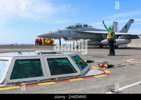 PHILIPPINISCHES MEER (Feb 3, 2022) eine F/A-18F Super Hornet, die den 'Black Aces' des Strike Fighter Squadron (VFA) 41 zugewiesen wurde, bereitet sich auf den Start vom Flugdeck des Nimitz-Klasse-Flugzeugträgers USS Abraham Lincoln (CVN 72) vor. Noble Fusion zeigt, dass die von der Marine und dem Marinekorps eingesetzten, einsatzbereiten Marineeinsatzkräfte als Marine Expeditionary Unit/Amphibious Ready Group-Team auf See agieren können, zusammen mit einer Trägerstreikgruppe, um tödliche Verweigerungsoperationen durchzuführen, wichtiges maritimes Terrain zu ergreifen, die Bewegungsfreiheit zu garantieren, Und schaffen Vorteile für uns, Partner und al Stockfoto