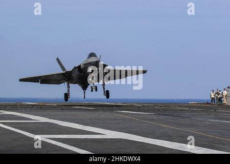 PHILIPPINISCHES MEER (Feb 3, 2022) eine F-35C Lightning II, die den "Black Knights" of Marine Fighter Attack Squadron (VMFA) 314 zugewiesen wurde, bereitet sich auf eine verhaftete Landung auf dem Flugdeck des Nimitz-Klasse-Flugzeugträgers USS Abraham Lincoln (CVN 72) vor. Noble Fusion zeigt, dass die von der Marine und dem Marinekorps eingesetzten, einsatzbereiten Marineeinsatzkräfte zusammen mit einer Trägerstreikgruppe auf See als Team der Marine Expeditionary Unit/Amphibious Ready Group agieren können, um tödliche Verweigerungsoperationen durchzuführen, wichtiges maritimes Terrain zu ergreifen, die Bewegungsfreiheit zu garantieren und adva zu schaffen Stockfoto