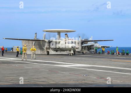 PHILIPPINISCHES MEER (Feb 3, 2022) eine E-2D Hawkeye, die den "Wallbangern" des Carrier Airborne Early Warning Squadron (VAW) 117 zugewiesen wurde, bereitet sich auf den Start vom Flugdeck des Flugzeugträgers USS Abraham Lincoln (CVN 72) der Nimitz-Klasse vor. Noble Fusion zeigt, dass die von der Marine und dem Marinekorps eingesetzten, einsatzbereiten Marineeinsatzkräfte als Marine Expeditionary Unit/Amphibious Ready Group-Team auf See agieren können, zusammen mit einer Trägerstreikgruppe, um tödliche Verweigerungsoperationen durchzuführen, wichtiges maritimes Terrain zu ergreifen, die Bewegungsfreiheit zu garantieren, Und zum Teil Vorteile für die USA schaffen Stockfoto